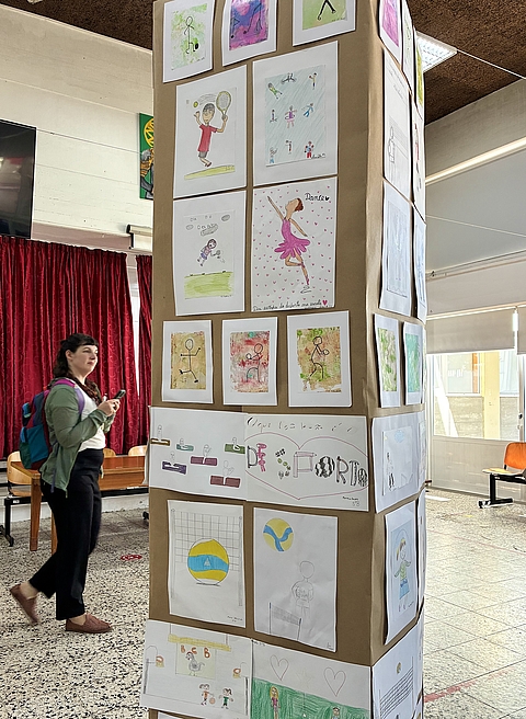 Eine Säule in einemgroßen Raum ist dekoriert mit diversen Kinderzeichnungen.