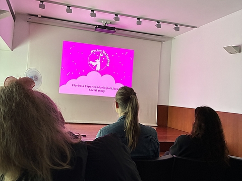 Die Gruppe lernt bei einer Präsentation mehr über die Bibliothek. 